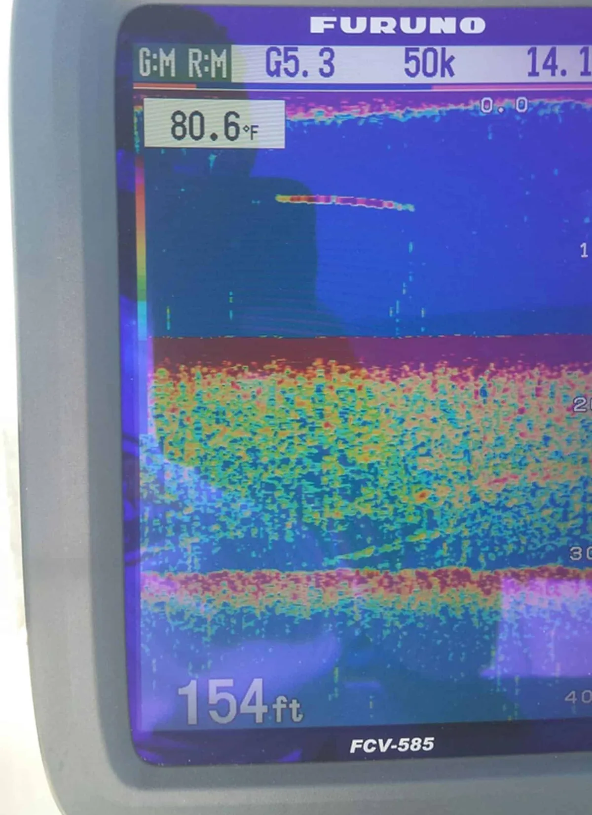 Photo of a Furuno fish finder off Arecibo, Puerto Rico, at 50 kHz showing a thick band of mixed red, yellow and green marks across the middle of the screen
