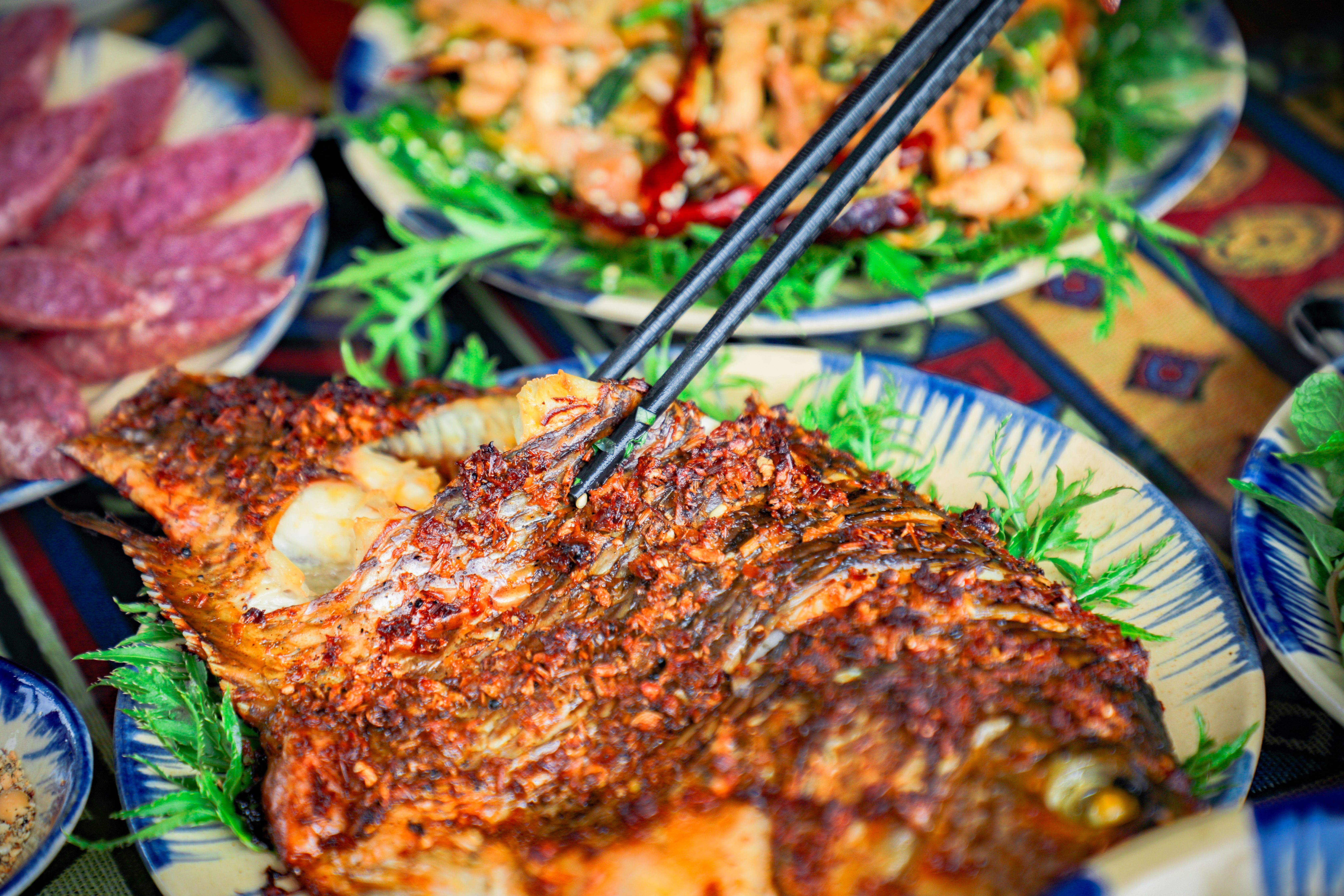 Grilled fish plated with colorful herbs and vegetables
